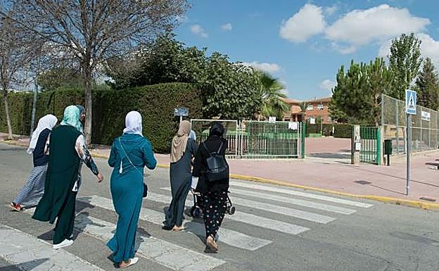 Un grupo de madres extranjeras acuden a recoger a sus hijos en un colegio de Roldán (imagen de archivo).