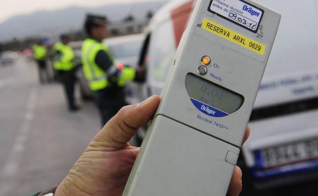 Un alcoholímetro en la mano de un agente de la policía.