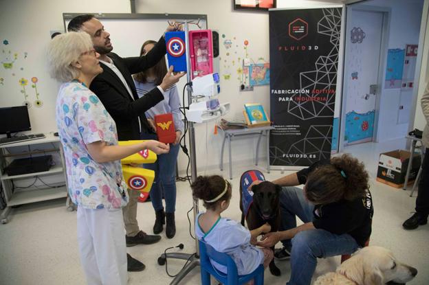 Asier Álvarez muestra a una enfermera una de las carcasas diseñadas para cubrir los sueros de los niños ingresados en Pediatría.