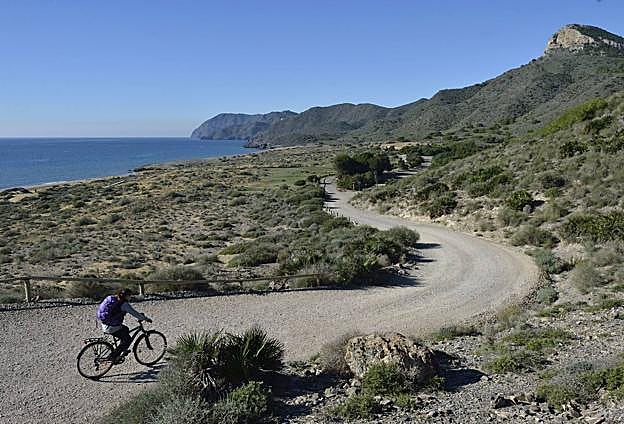 Descenso desde el mirador de playa Larga, en dirección a playa Negrete, por la pista que sigue el itinerario del GR, con el picudo Cabezo de la Fuente a la derecha.