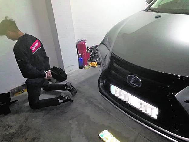 El joven ucraniano, con los grilletes, junto al Lexus robado. 