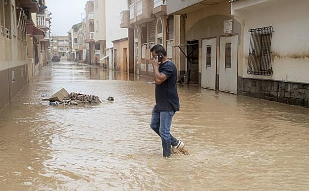 Un hombre cruza una calle completamente anegada en Los Alcázares. 