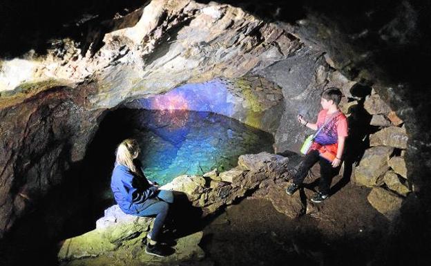 Unos niños observan el lago subterráneo de la Cueva del Agua, en el Cabezo Gordo de Torre Pacheco.