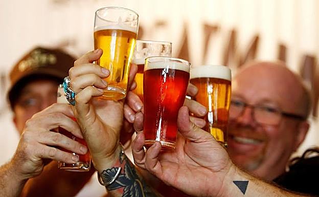 Un grupo de personas brindando con cerveza, en una fotografía de archivo.