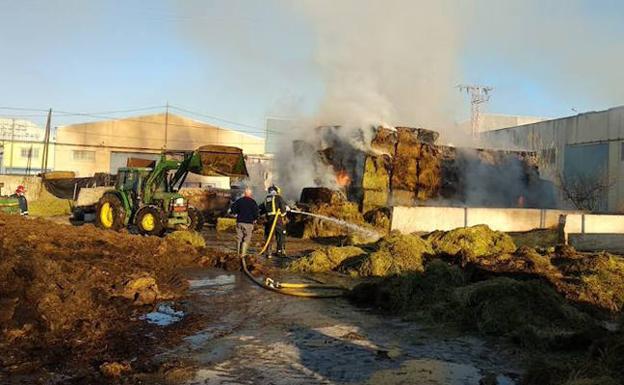 El fuego consume varias pilas de balas de paja en una granja de Santomera