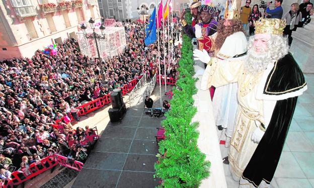 Baltasar, Gaspar y, en primer término, Melchor, saludan al público desde el balcón del Palacio Consistorial, por la mañana. 