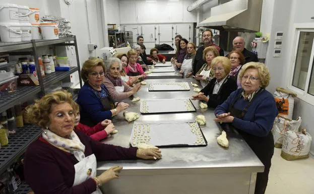 Un grupo de mujeres amasa harina para hacer los panecillos de San Antón.