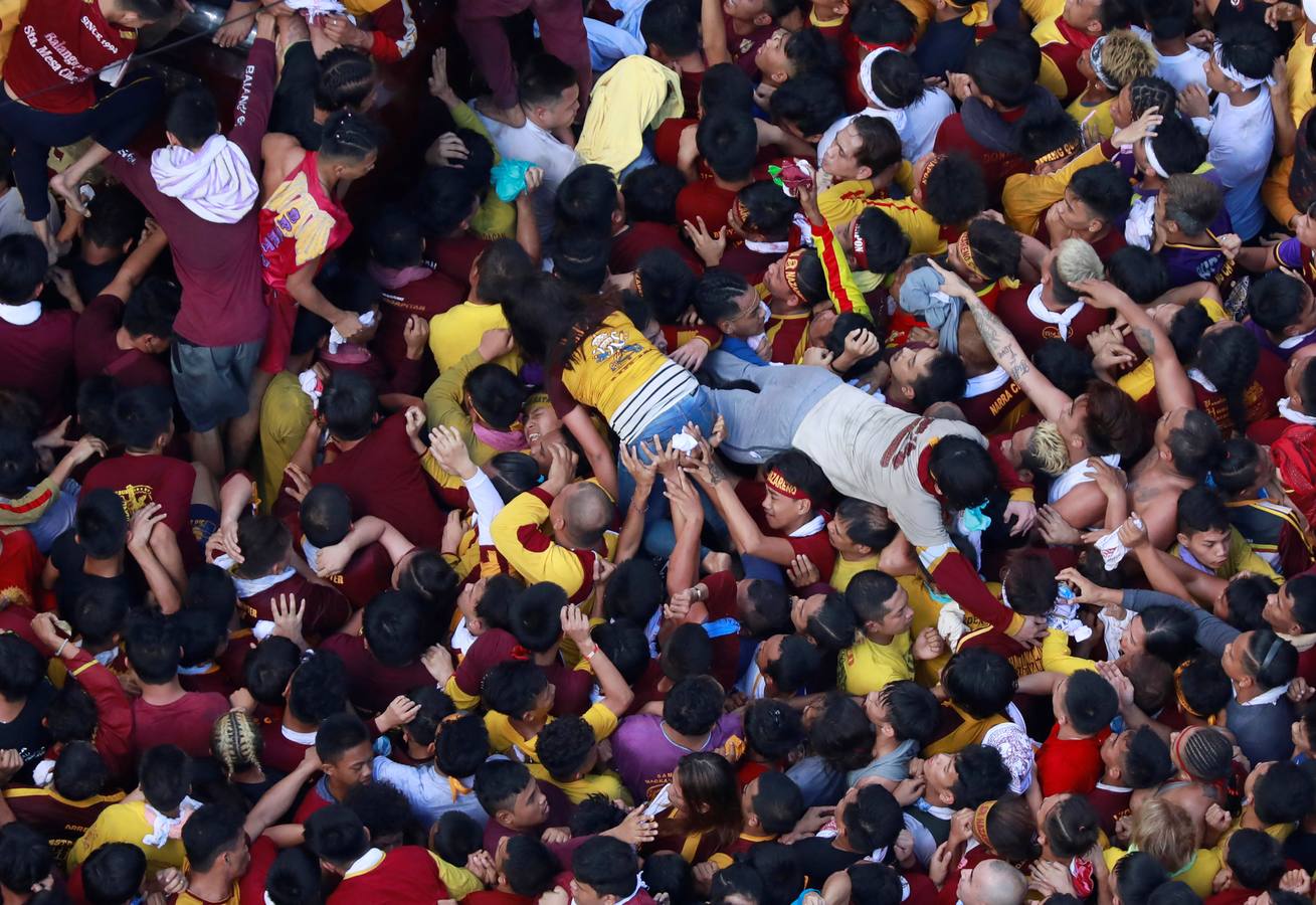 Devotos católicos descalzos empujan durante la procesión en un intento por tocar el Nazareno Negro, una estatua centenaria de un Jesucristo sufriente. Se dice que la estatua de madera de tamaño natural fue traída a Manila (Filipinas), por un sacerdote español.