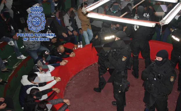 Decenas de arrestados vigilados por agentes de la Policía Nacional. 
