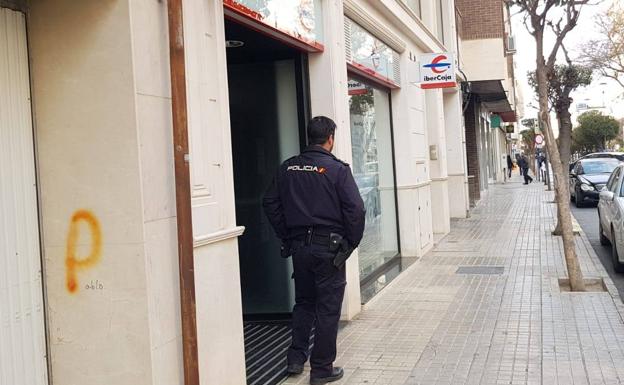 Un agente de la Policía Nacional, a la entrada de la oficina bancaria donde se ha producido el atraco.