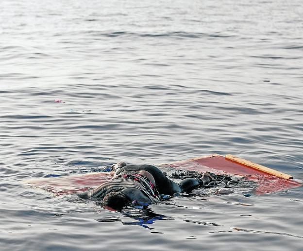 El cuerpo de una mujer yace sobre unas tablas flotando en el mar frente a las costas de Libia.