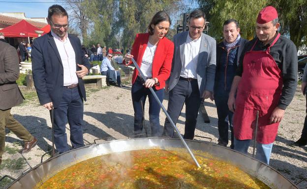 La ministra Reyes Maroto moviendo ayer el arroz junto a Diego José Mateos, Diego Conesa, José Luis Ruiz y Juan Pozo. 