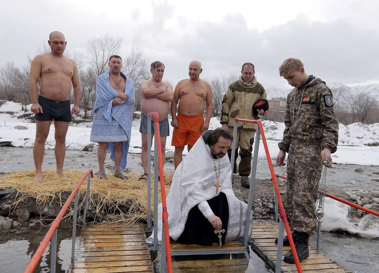 Varias personas se dan un baño en las aguas heladas de un lago para celebrar la Epifanía, cerca de la localidad de Vorontsovka, Biskek (Kirguistán). Los fieles creen que darse un chapuzón en aguas bendecidas fortalece cuerpo y espíritu.