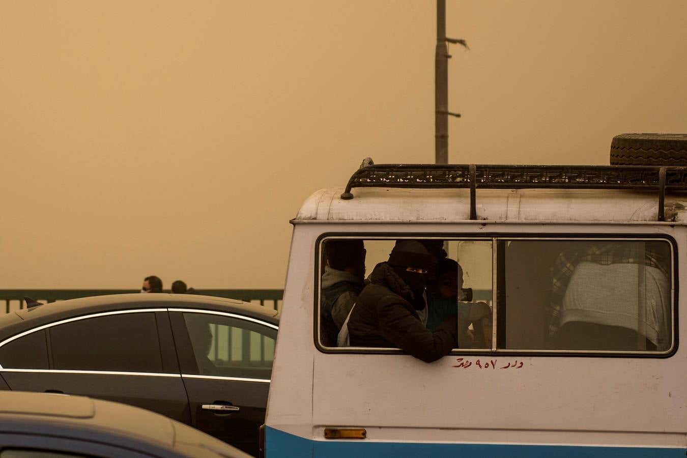 Varias personas se cubren el rostro durante una tormenta de arena en El Cairo, Egipto. La tormenta provocó que varios zoos y parques tuvieran que cerrar sus puertas al público.