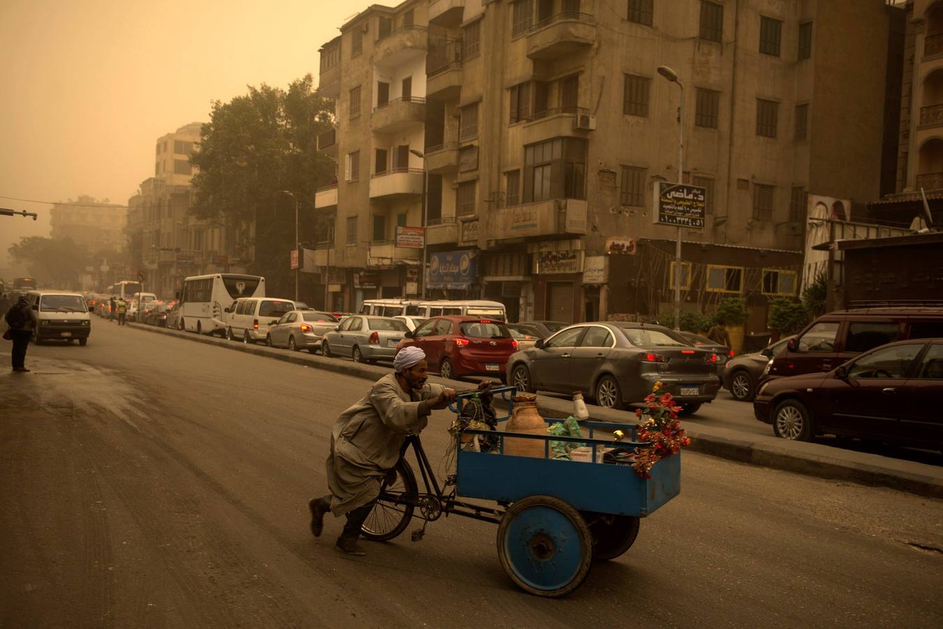 Varias personas se cubren el rostro durante una tormenta de arena en El Cairo, Egipto. La tormenta provocó que varios zoos y parques tuvieran que cerrar sus puertas al público.