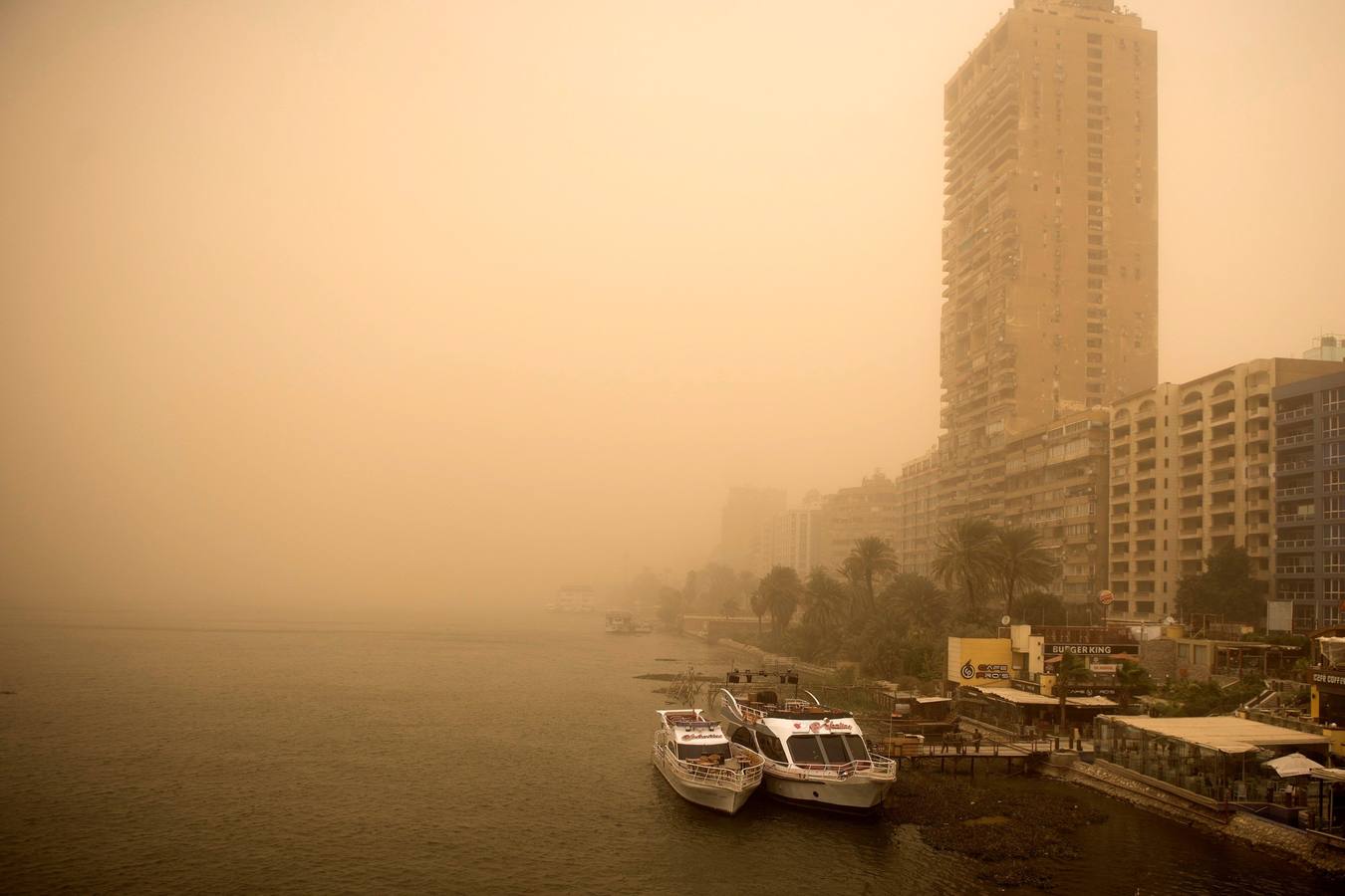 Varias personas se cubren el rostro durante una tormenta de arena en El Cairo, Egipto. La tormenta provocó que varios zoos y parques tuvieran que cerrar sus puertas al público.