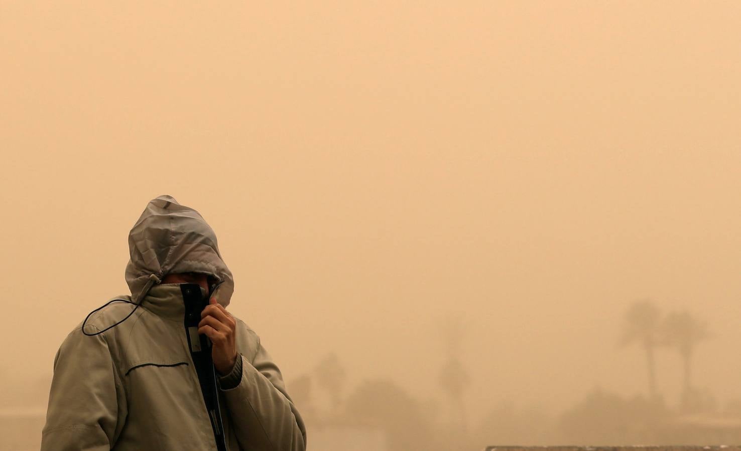 Varias personas se cubren el rostro durante una tormenta de arena en El Cairo, Egipto. La tormenta provocó que varios zoos y parques tuvieran que cerrar sus puertas al público.