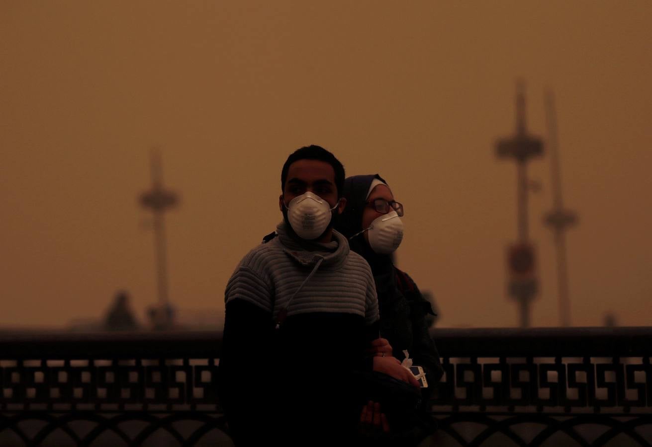 Varias personas se cubren el rostro durante una tormenta de arena en El Cairo, Egipto. La tormenta provocó que varios zoos y parques tuvieran que cerrar sus puertas al público.