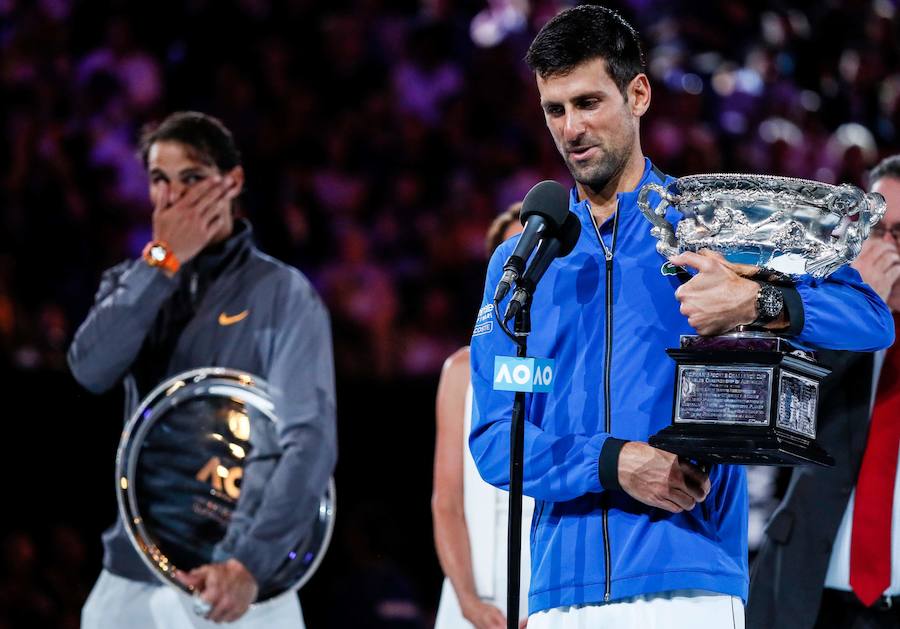 Djokovic, con el trofeo, con Nadal al fondo. 