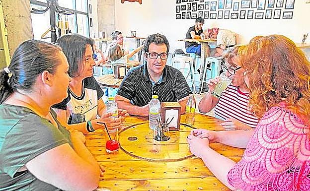 Una Voluntaria merieda con usuarios de Asido y Astus.