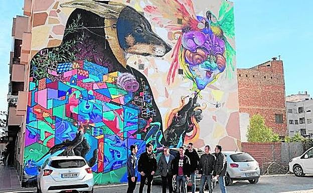 Miembros de la Asociación del Carnaval, con Fran Sánchez (c), ayer, delante del grafiti. 
