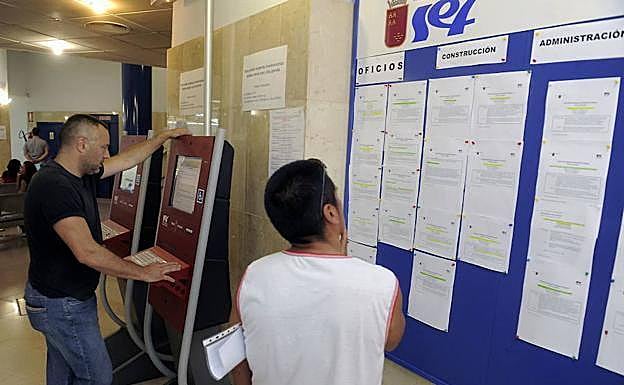 Un joven mira ofertas de trabajo en una oficina del SEF.
