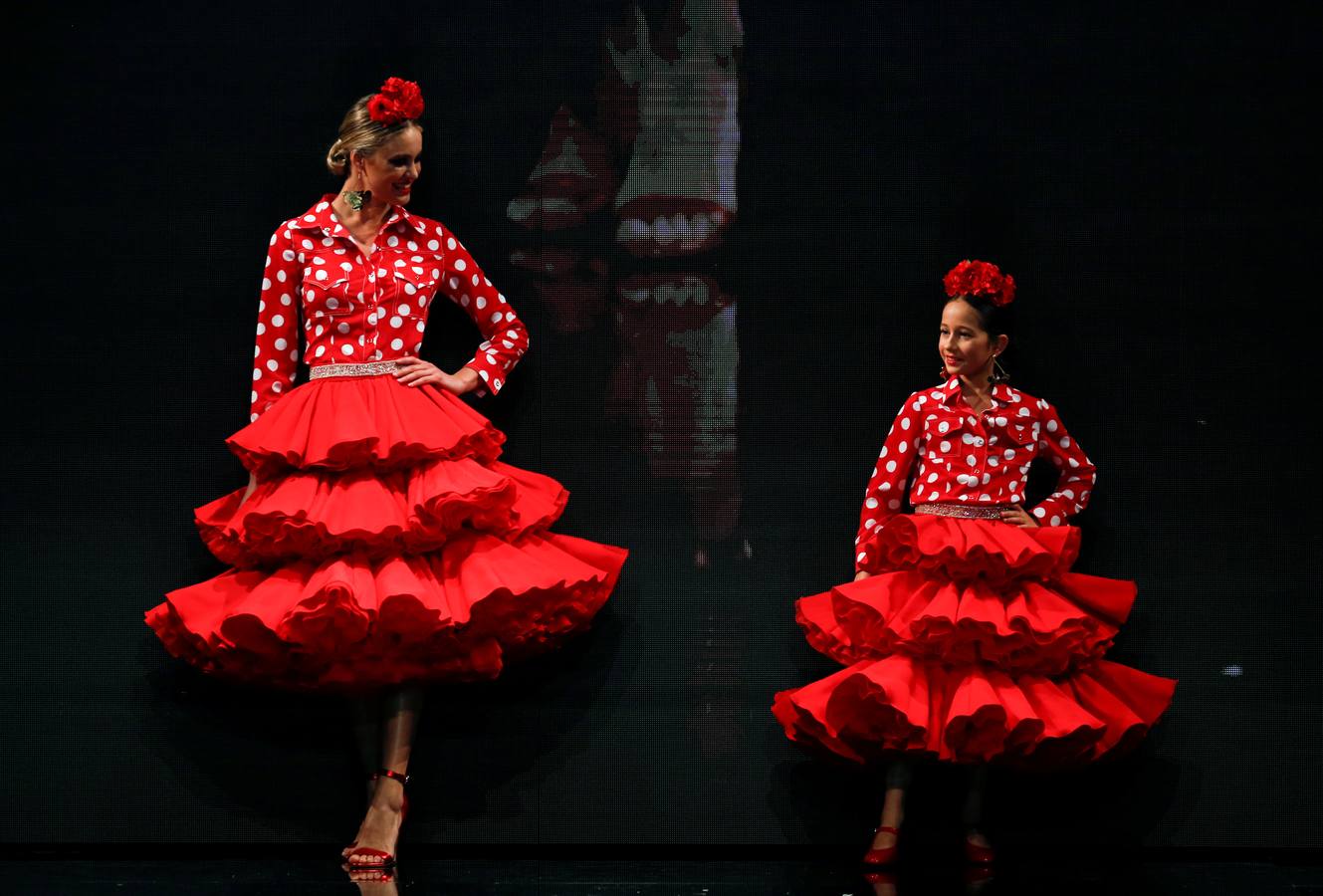 Varias modelos desfilan dentro del salón internacional de moda flamenca SIMOF, en Sevilla, que este año celebra su 25 aniversario.