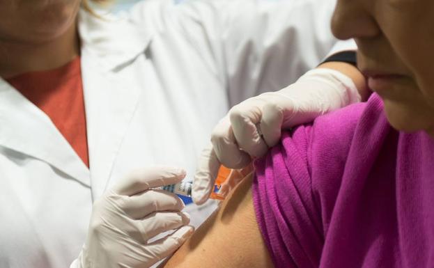 Una mujer recibe una dosis de la vacuna contra la gripe. 