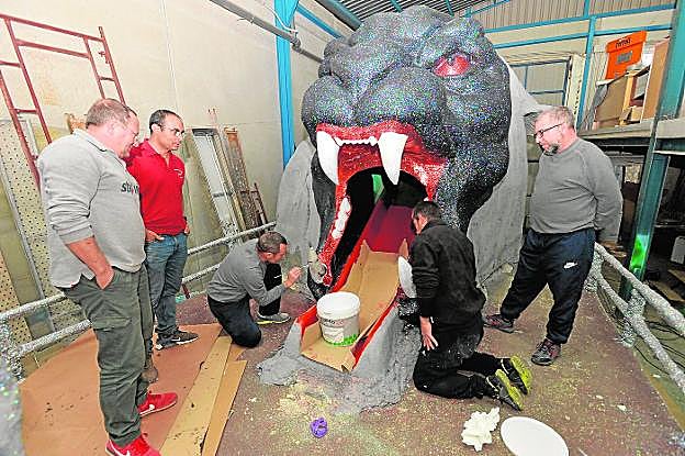 Varios miembros de la peña Matalentisco Boys terminan de pintar una de las carrozas que desfilará por las calles de Águilas. 