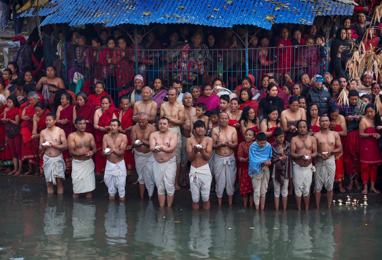 Devotos toman un baño sagrado en el río Hanumante durante el último día del Festival Madhav Narayan en Bhaktapur (Nepal). El Madhay Narayan se celebra durante un mes completo en el que se toman baños sagrados para lavar los pecados y se estudia el libro Swasthani. La veneración a la diosa Swasthani, una festividad que solo se conmemora en Nepal, es única en cada pueblo, con celebraciones y tradiciones diferentes.