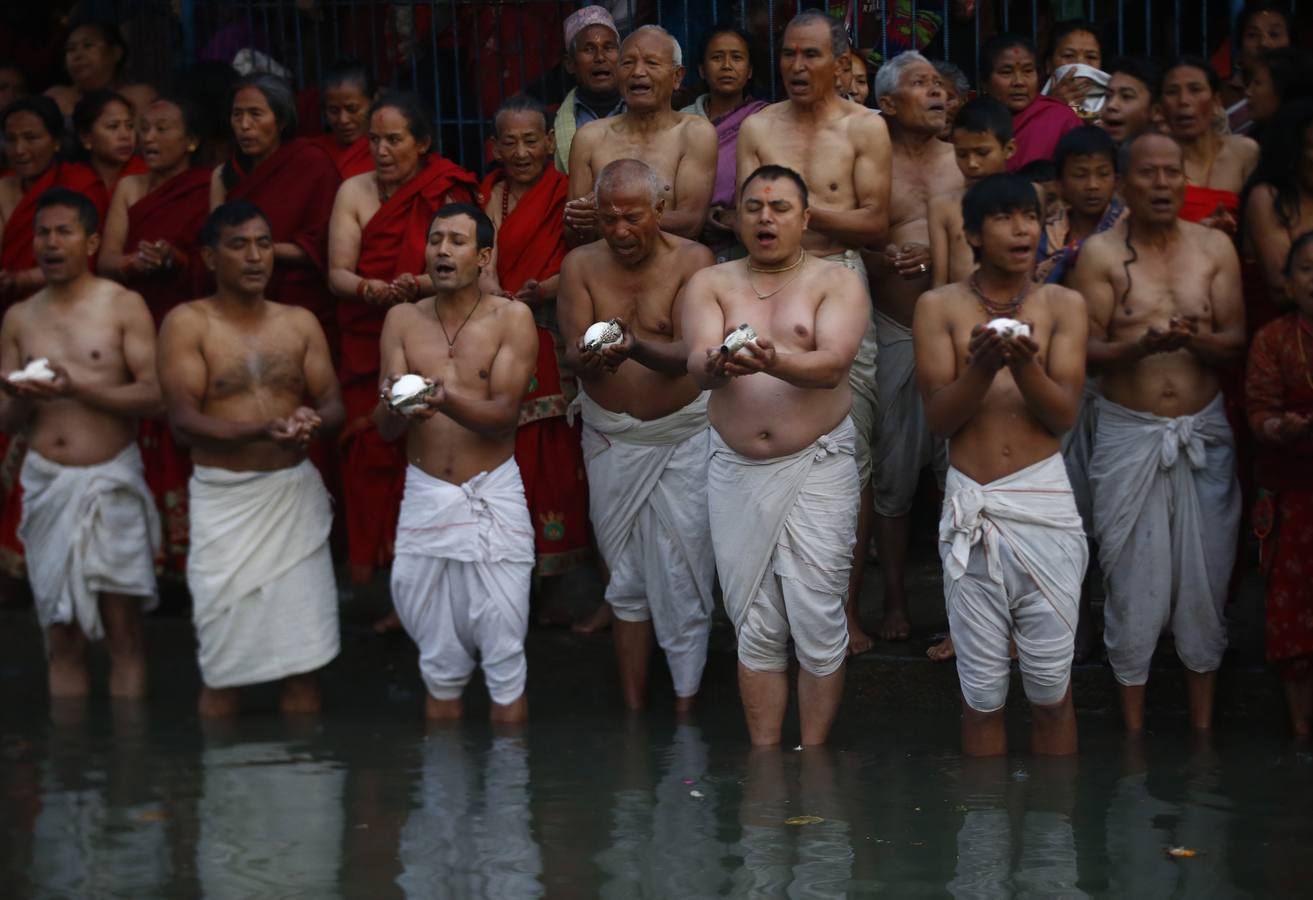 Devotos toman un baño sagrado en el río Hanumante durante el último día del Festival Madhav Narayan en Bhaktapur (Nepal). El Madhay Narayan se celebra durante un mes completo en el que se toman baños sagrados para lavar los pecados y se estudia el libro Swasthani. La veneración a la diosa Swasthani, una festividad que solo se conmemora en Nepal, es única en cada pueblo, con celebraciones y tradiciones diferentes.