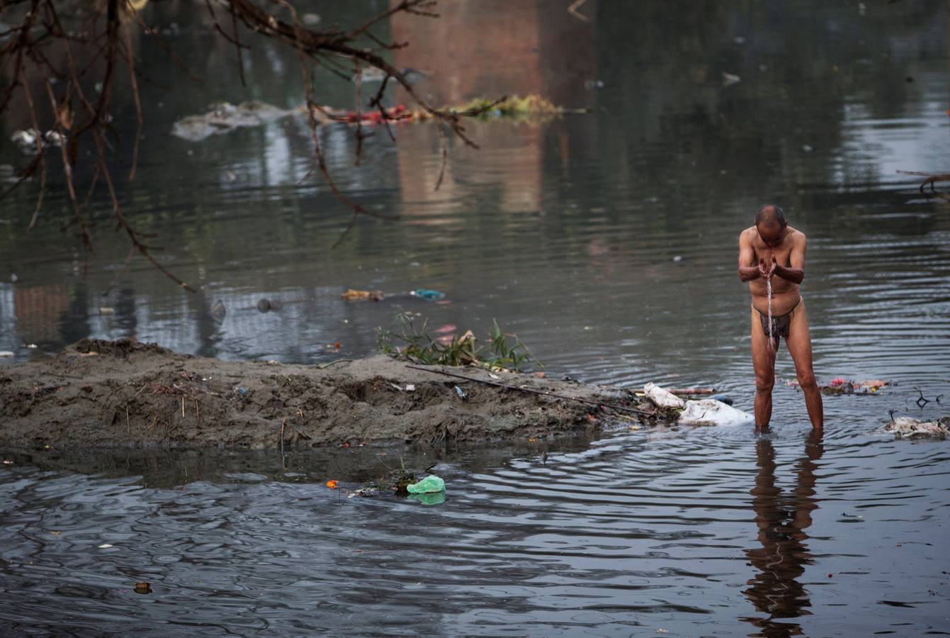 Devotos toman un baño sagrado en el río Hanumante durante el último día del Festival Madhav Narayan en Bhaktapur (Nepal). El Madhay Narayan se celebra durante un mes completo en el que se toman baños sagrados para lavar los pecados y se estudia el libro Swasthani. La veneración a la diosa Swasthani, una festividad que solo se conmemora en Nepal, es única en cada pueblo, con celebraciones y tradiciones diferentes.