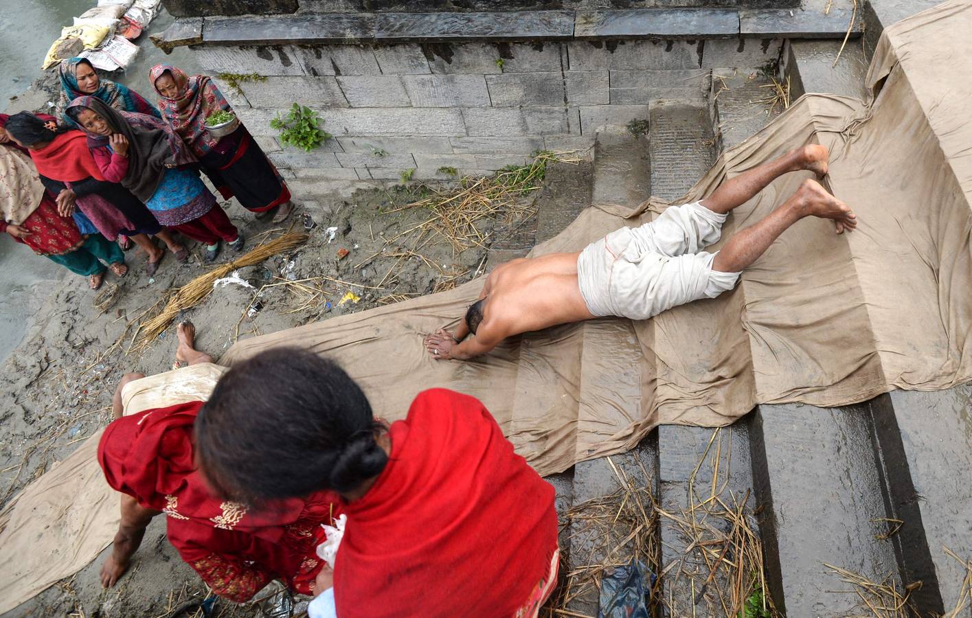 Devotos toman un baño sagrado en el río Hanumante durante el último día del Festival Madhav Narayan en Bhaktapur (Nepal). El Madhay Narayan se celebra durante un mes completo en el que se toman baños sagrados para lavar los pecados y se estudia el libro Swasthani. La veneración a la diosa Swasthani, una festividad que solo se conmemora en Nepal, es única en cada pueblo, con celebraciones y tradiciones diferentes.