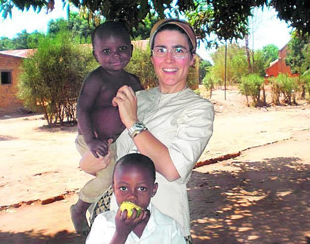 La religiosa Victoria Braquehais, con dos niños del poblado congoleño de Kanzenze. 