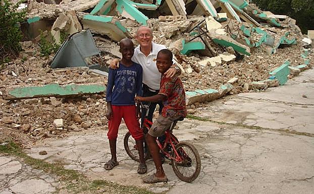 Linares, con dos niños haitianos tras el terremoto que asoló la isla. 