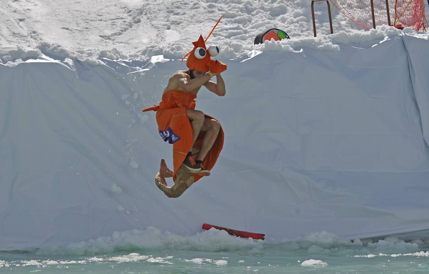 Varios participantes participan en competención Red Bull Jump and Freeze en la estación de esquí Mzaar en Kfardebian Lebanon Mountain, en Kfardebian, Líbano. Los participantes que usan trajes festivos realizan piruetas antes de meterse en un estanque con agua helada. 