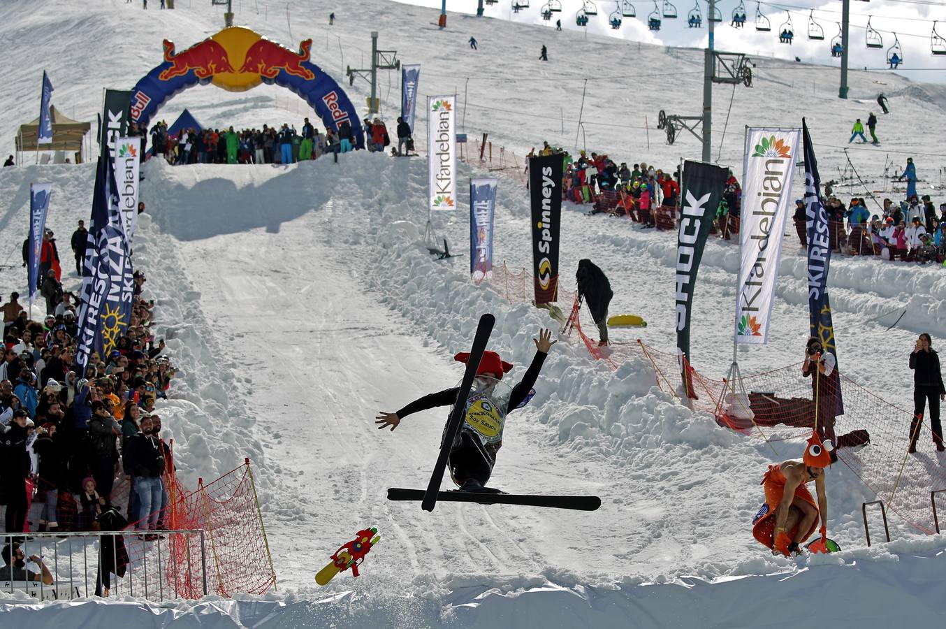Varios participantes participan en competención Red Bull Jump and Freeze en la estación de esquí Mzaar en Kfardebian Lebanon Mountain, en Kfardebian, Líbano. Los participantes que usan trajes festivos realizan piruetas antes de meterse en un estanque con agua helada. 