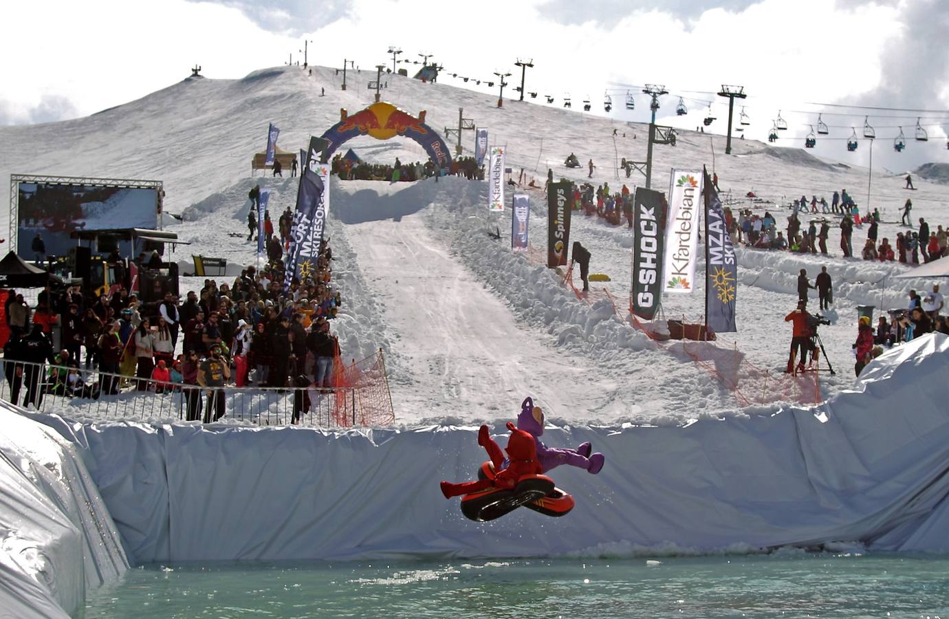 Varios participantes participan en competención Red Bull Jump and Freeze en la estación de esquí Mzaar en Kfardebian Lebanon Mountain, en Kfardebian, Líbano. Los participantes que usan trajes festivos realizan piruetas antes de meterse en un estanque con agua helada. 