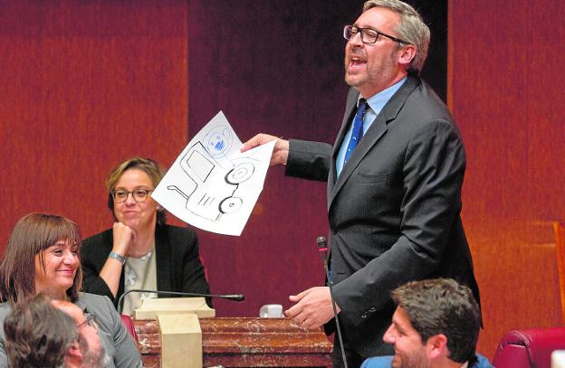 El portavoz del PP muestra el dibujo de un tractor, durante su intervención en el Pleno. 