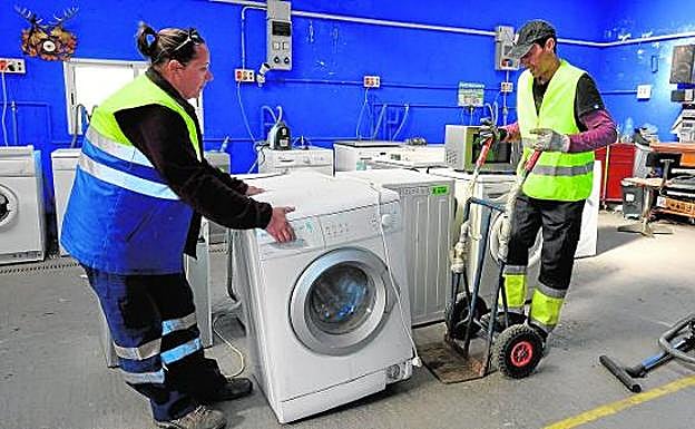 Dos voluntarios en el interior de las instalaciones de Traperos de Emaús.