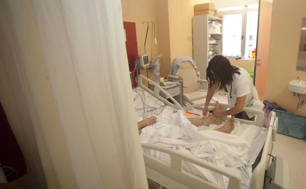 Una enfermera atiende a un paciente ingresado en la Unidad de Ictus del Hospital Santa Lucía.