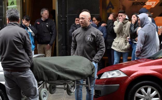 Los servicios funerarios sacan el cuerpo del joven muerto en el incendio de su vivienda, en Bermeo (Vizcaya).