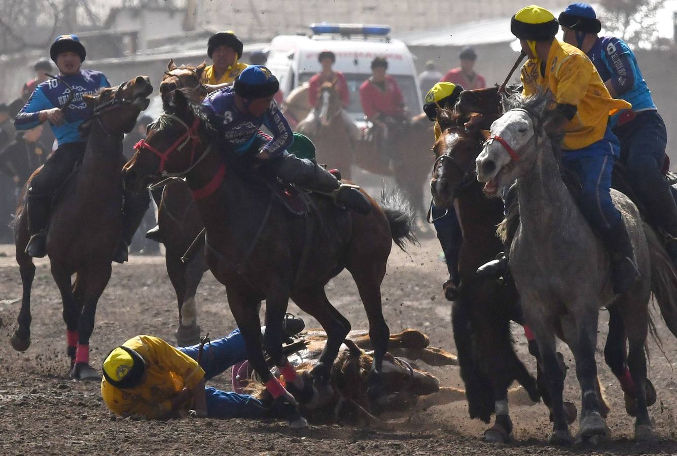 Varios jinetes participan en la competición tradicional kirguizistana llamada 'Kok-Boru', o arrastre de la cabra, con motivo de las celebraciones del Año Nuevo en el calendario solar persa, en Biskek (Kirguizistán). En el Kok-Boru los jugadores deben agarrar el cuerpo de una cabra desde el suelo mientras montan a caballo e intentar anotar un tanto al dejarlo sobre la portería del contrario.
