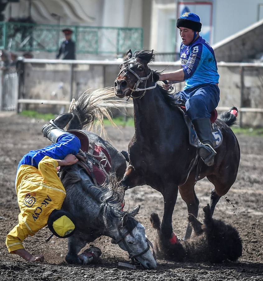 Varios jinetes participan en la competición tradicional kirguizistana llamada 'Kok-Boru', o arrastre de la cabra, con motivo de las celebraciones del Año Nuevo en el calendario solar persa, en Biskek (Kirguizistán). En el Kok-Boru los jugadores deben agarrar el cuerpo de una cabra desde el suelo mientras montan a caballo e intentar anotar un tanto al dejarlo sobre la portería del contrario.