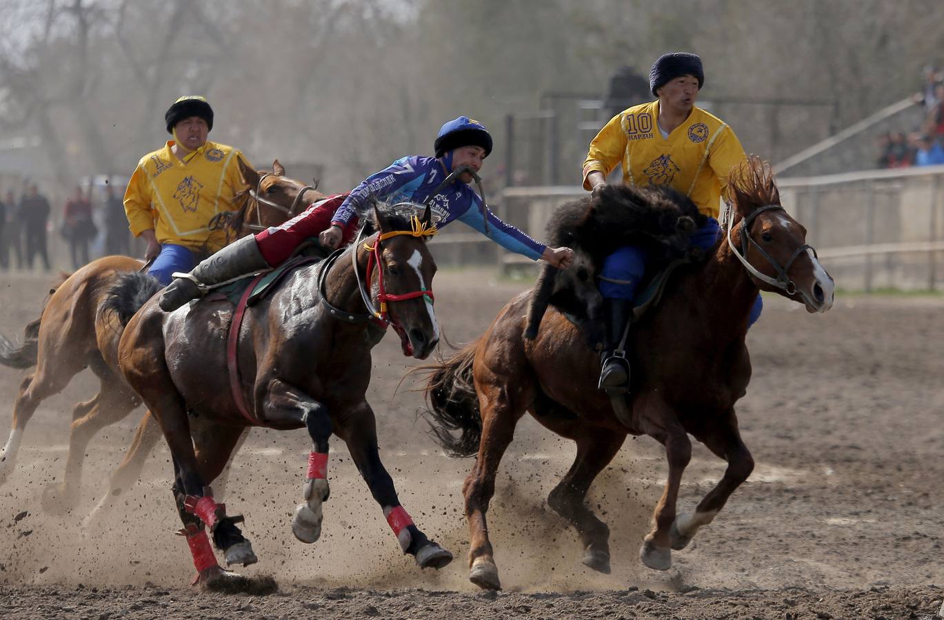 Varios jinetes participan en la competición tradicional kirguizistana llamada 'Kok-Boru', o arrastre de la cabra, con motivo de las celebraciones del Año Nuevo en el calendario solar persa, en Biskek (Kirguizistán). En el Kok-Boru los jugadores deben agarrar el cuerpo de una cabra desde el suelo mientras montan a caballo e intentar anotar un tanto al dejarlo sobre la portería del contrario.