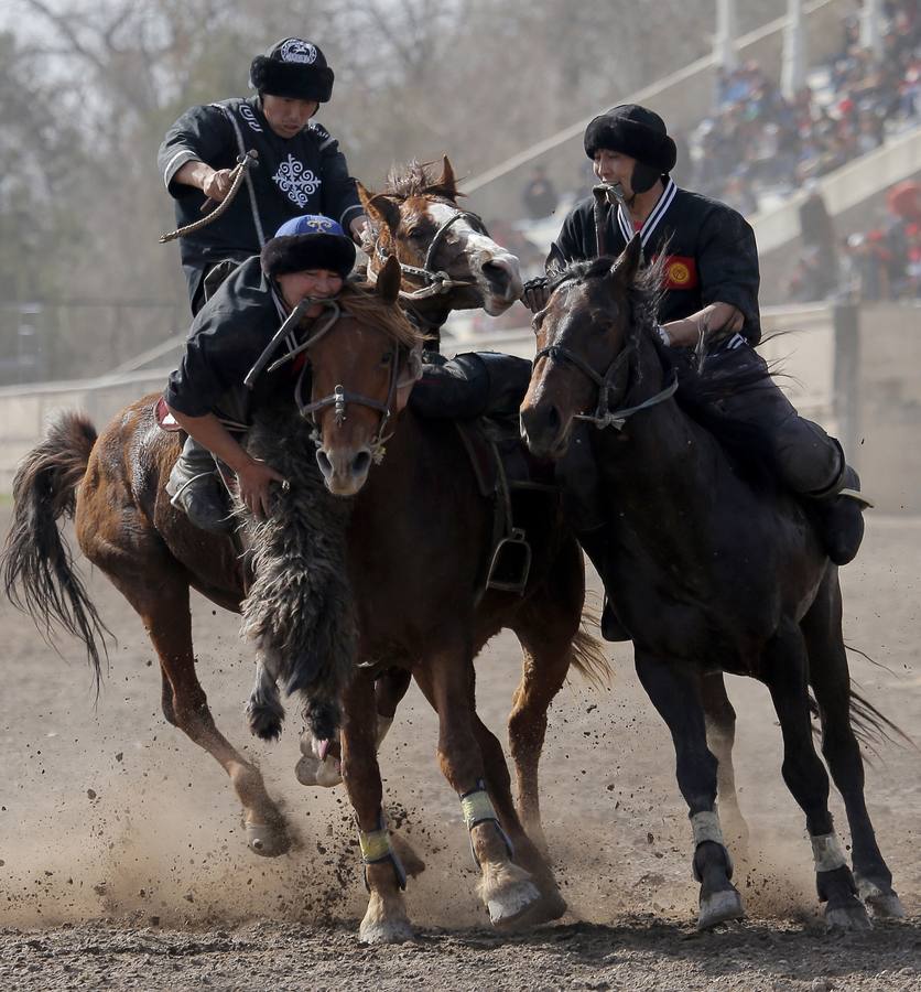 Varios jinetes participan en la competición tradicional kirguizistana llamada 'Kok-Boru', o arrastre de la cabra, con motivo de las celebraciones del Año Nuevo en el calendario solar persa, en Biskek (Kirguizistán). En el Kok-Boru los jugadores deben agarrar el cuerpo de una cabra desde el suelo mientras montan a caballo e intentar anotar un tanto al dejarlo sobre la portería del contrario.