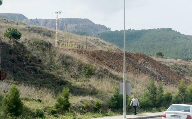 Un hombre camina por La Unión, con el antiguo depósito minero 'El Descargador' al fondo.