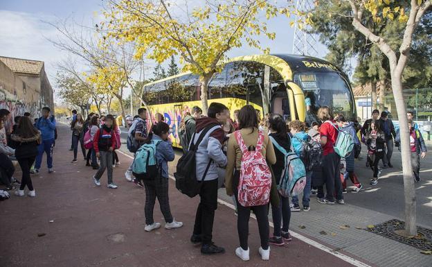 Alumnos alrededor de un autobús escolar. 