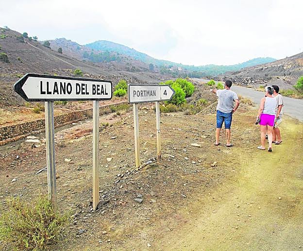Vecinos de Llano del Beal observan una zona afectada por residuos mineros pendientes de restaurar, en agosto de 2018. 