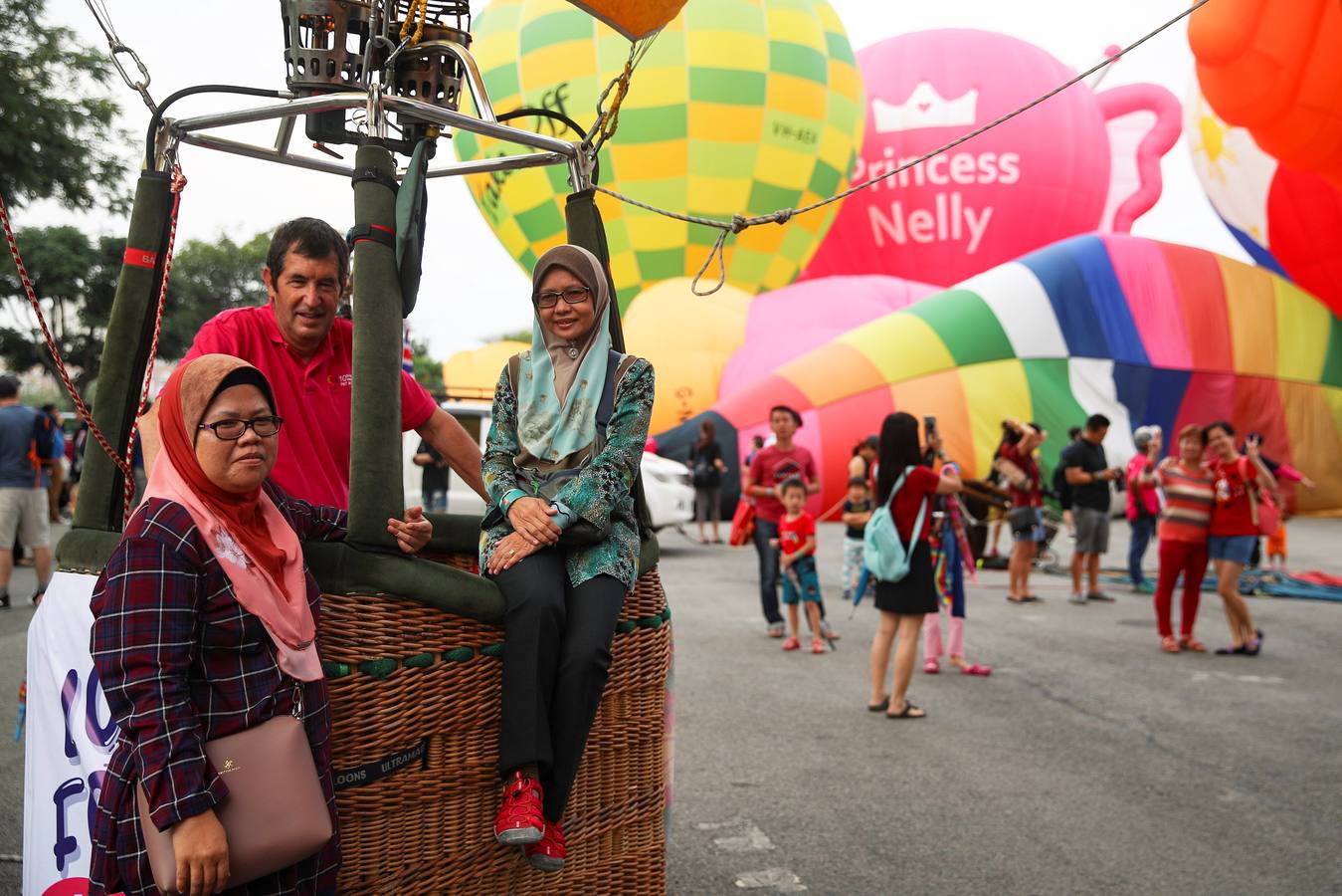 Varias personas asisten a la décima Fiesta Internacional de Globos Aerostáticos de Putrajaya (Malasia). Más de 20 globos aerostáticos volaron por los cielos en la fiesta anual, organizada para promover el turismo y los deportes de aviación. 